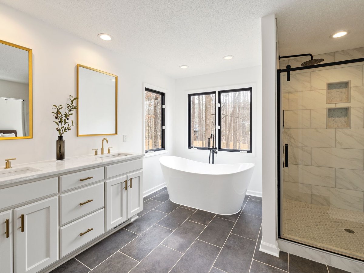 Salle de bain rénovée avec double vasque, baignoire îlot et douche vitrée