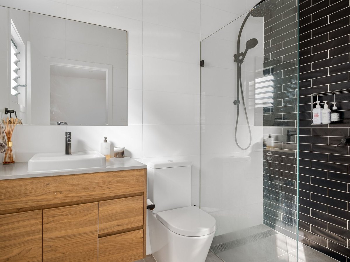 Salle de bain contemporaine avec meuble en bois, vasque et robinetterie noire